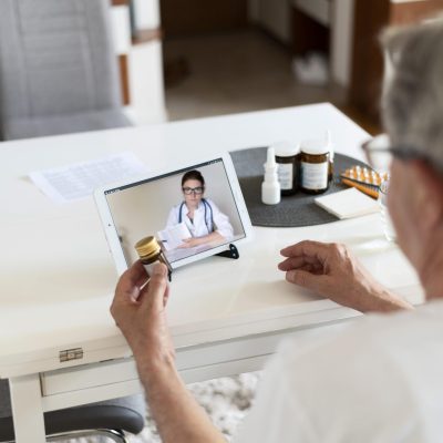 close-up-old-man-talking-online-doctor
